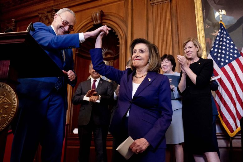 Senate Majority Leader Sen. Chuck Schumer of New York high-fives House Speaker Nancy Pelosi of California before she signs H.R. 8404, the Respect for Marriage Act, at a signing ceremony on Capitol Hill in Washington, D.C., on Thursday. (Andrew Harnik / The Associated Press)