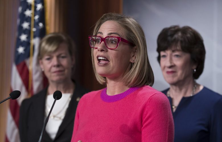 Sen. Kyrsten Sinema, D-Ariz., flanked by Sen. Tammy Baldwin, D-Wis., left, and Sen. Susan Collins, R-Maine, speaks to reporters following Senate passage of the Respect for Marriage Act, at the Capitol in Washington, Tuesday, Nov. 29, 2022. (AP Photo/J. Scott Applewhite) DCSA134 DCSA134