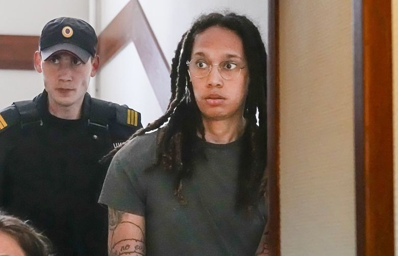 WNBA star and two-time Olympic gold medalist Brittney Griner is escorted to a courtroom for a hearing, in Khimki just outside Moscow, Russia, Monday, June 27, 2022. More than four months after she was arrested at a Moscow airport for cannabis possession, American basketball star Brittney Griner is to appear in court Monday for a preliminary hearing ahead of her trial. (AP Photo/Alexander Zemlianichenko) XAZ147