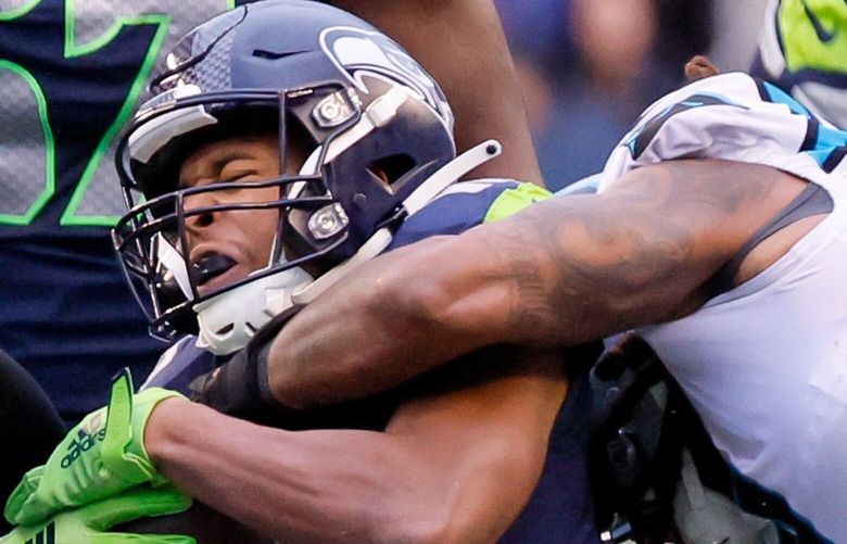 Seattle Seahawks wide receiver Tyler Lockett gets collared down by Carolina Panthers linebacker Shaq Thompson, right, and defensive end Yetur Gross-Matos during the second quarter. 222421