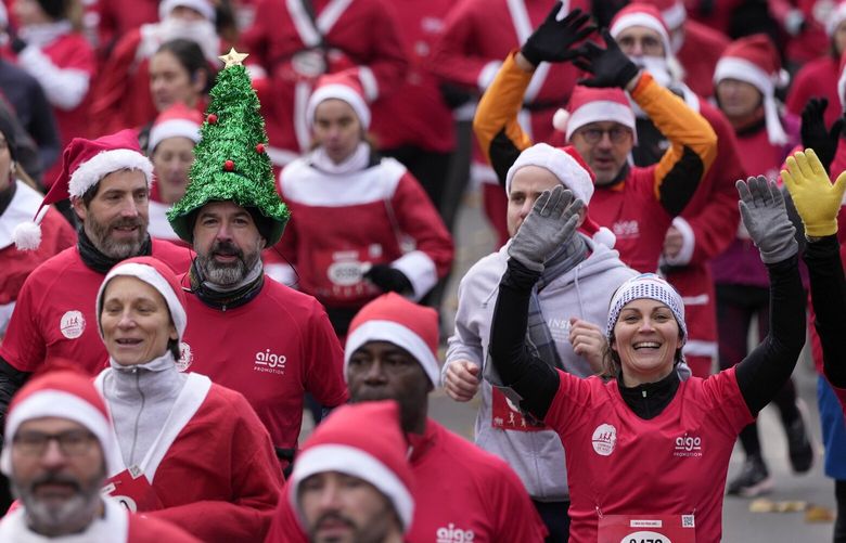 Runners, dressed as Santa Claus, take part in the “Christmas Corrida Race” in the streets of Issy Les Moulineaux, outside Paris, Sunday, Dec. 11, 2022. (AP Photo/Francois Mori) XFM104 XFM104