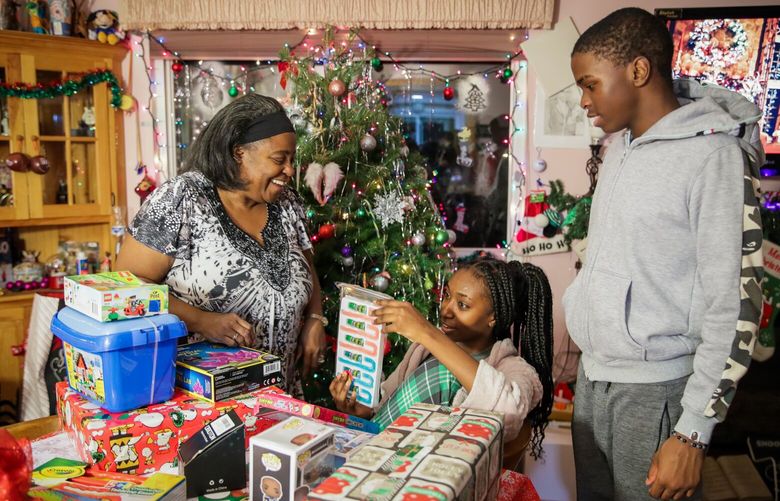 Reshell Wilson shares a laugh with her grandchildren Tamia Wilson, 13, and Tashaun Wilson, 14, Monday night at their home in Auburn, Washington on December 12, 2022.