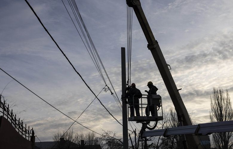 Workers fix power lines in a residential neighborhood in Dnipro, Ukraine, on Dec. 1. MUST CREDIT: Photo by Heidi Levine for The Washington Post.