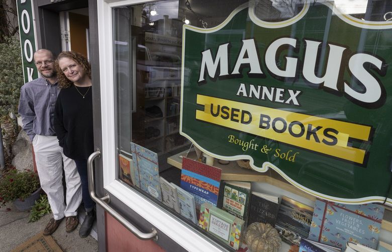 Chris Weimer (l) and Hanna McElroy, owners of Magus Books, stand in the doorway of their new bookstore which is located in Seattleâ€™s Wallingford neighborhood, Wednesday, December 14, 2022.  The store opened in October and is their second store. 

This month’s edition of Neighborhood Reads is on Magus Books, which now has a new location in Wallingford, in addition to their longtime store in the University District. Their Wallingford location is open daily from 11 a.m. to 7 p.m.  222448