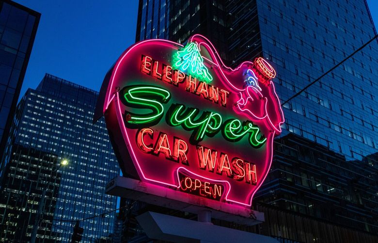 The pink Elephant Car Wash sign is reinstalled and lit up for the first time at 7th Avenue and Blanchard Street in South Lake Union on Thursday, Dec. 15, 2022.