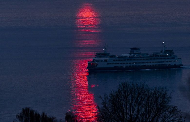 A fiery beam of light rides the Washington waters as the last moments of light adorns the sky on Tuesday, Dec. 13, 2022.