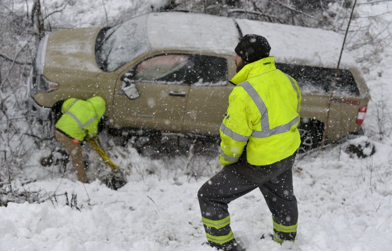 Trevor Kirker, a heavy wrecker operator for A’s Auto and Truck Repair in Guilford, watches as others hook up a truck at a three-vehicle crash site during a snowstorm on Friday, Dec. 16, 2022, in Jamaica, Vt.Â  (Kristopher Radder/The Brattleboro Reformer via AP) VTBRA205 VTBRA205