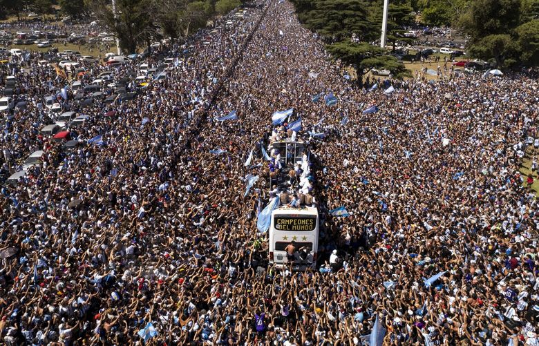 The Argentine soccer team that won the World Cup title ride on an open bus during their homecoming parade in Buenos Aires, Argentina, Tuesday, Dec. 20, 2022. (AP Photo/Rodrigo Abd) XRM604 XRM604