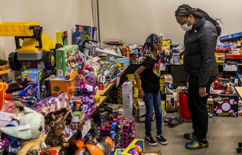 Aujamari Cook, right, and her daughter look through gifts from the gift drive at Wellspring Family Services on Wednesday, Dec. 15, 2022.