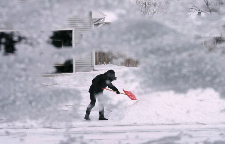 A local resident shovels snow off the end of a driveway, Thursday, Dec. 22, 2022, in Urbandale, Iowa. Temperatures plunged far and fast Thursday as a winter storm formed ahead of Christmas weekend, promising heavy snow, ice, flooding and powerful winds across a broad swath of the country and complicating holiday travel. (AP Photo/Charlie Neibergall) IACN109 IACN109