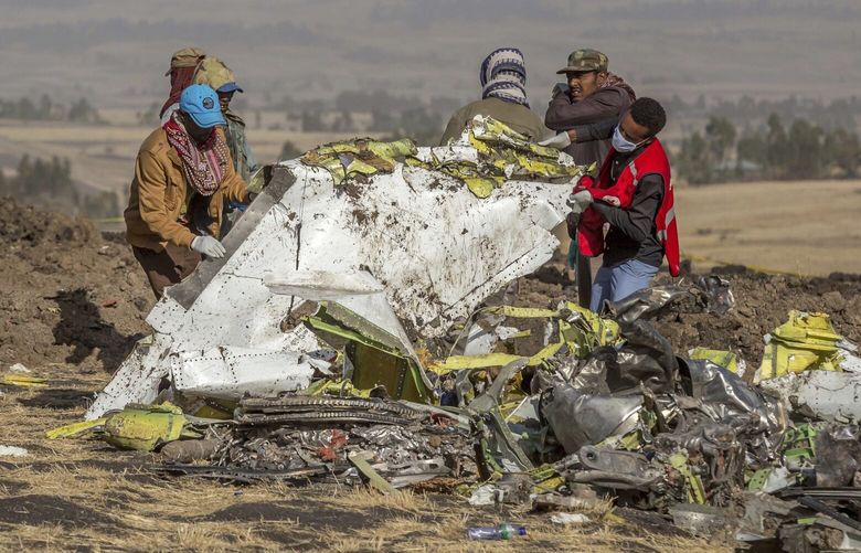 Rescuers work at the scene of an Ethiopian Airlines flight crash near Bishoftu, or Debre Zeit, south of Addis Ababa,  Ethiopia, Monday, March 11, 2019. A spokesman says Ethiopian Airlines has grounded all its Boeing 737 Max 8 aircraft as a safety precaution, following the crash of one of its planes in which 157 people were killed. (AP Photo/Mulugeta Ayene)