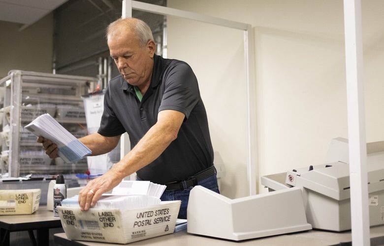 Randy Dahl, elections worker, runs ballot envelopes through a letter opener at the Yakima County Courthouse Thursday, Nov. 10, 2022, in Yakima, Wash.