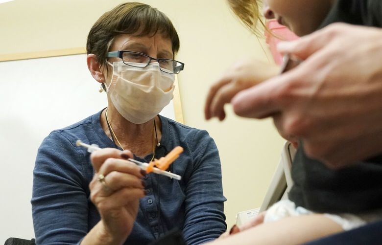 Deborah Sampson, left, a nurse at a University of Washington Medical Center clinic in Seattle, gives a Pfizer COVID-19 vaccine shot to a 20-month-old child, June 21, 2022, in Seattle. The U.S. on Thursday, Dec. 8, 2022 open doses of the updated COVID-19 vaccines for most children younger than age 5. The Food and Drug Administration’s decision aims to better protect the littlest kids from severe COVID-19 at a time when childrenâ€™s hospitals already are packed with tots suffering a variety of other respiratory illnesses, too. (AP Photo/Ted S. Warren, file) NYPS206 NYPS206