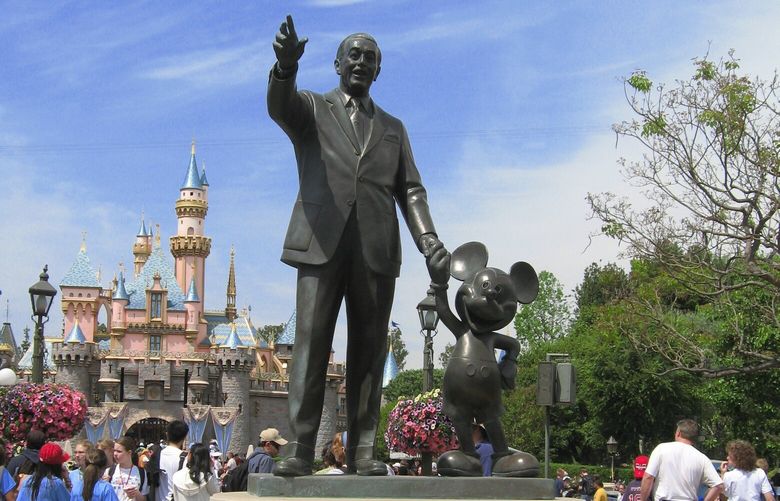  Statue of Walt Disney holding hands with Mickey Mouse at Disneyland in California. 