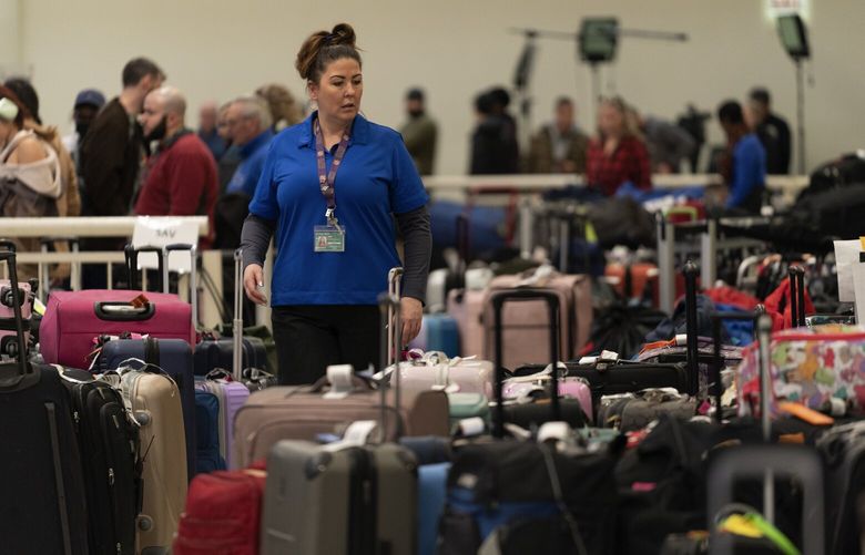 A Southwest Airlines employee helps a traveler search for bags amongst hundreds of other checked bags at baggage claim at Midway International Airport as Southwest continues to cancel thousands of flights across the country Wednesday, Dec. 28, 2022, in Chicago. (AP Photo/Erin Hooley) ILEH110 ILEH110