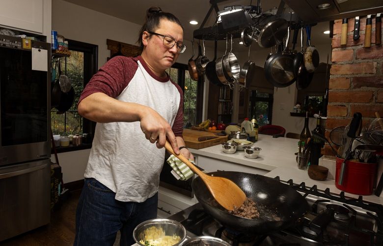 J. Kenji López-Alt, author of “The Wok,” browns ground beef inside his kitchen, Monday, Dec. 12, 2022 in Seattle. López-Alt makes the “My Mom’s Japanese-Style Mapo Tofu” recipe from his book.