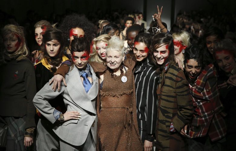 FILE – British designer Vivienne Westwood poses with models after her Autumn/Winter 2015 show at London Fashion Week in London, Feb. 22, 2015. Westwood, an influential fashion maverick who played a key role in the punk movement, died Thursday, Dec. 29, 2022, at 81. (AP Photo/Alastair Grant, File) NYSS427 NYSS427