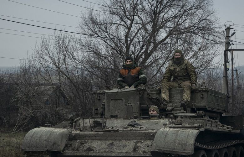 Ukrainian soldiers ride atop an armored vehicle in the Donetsk region of Ukraine, on Saturday, Dec. 31, 2022. Russia rained missiles and exploding drones on Ukraine’s capital and other cities on Saturday in a deadly New Year’s Eve assault, punctuating Russian President Vladimir Putin’s stated resolve in a speech to continue a war he called a “sacred duty to our ancestors and descendants.” (Nicole Tung/The New York Times) XNYT107 XNYT107