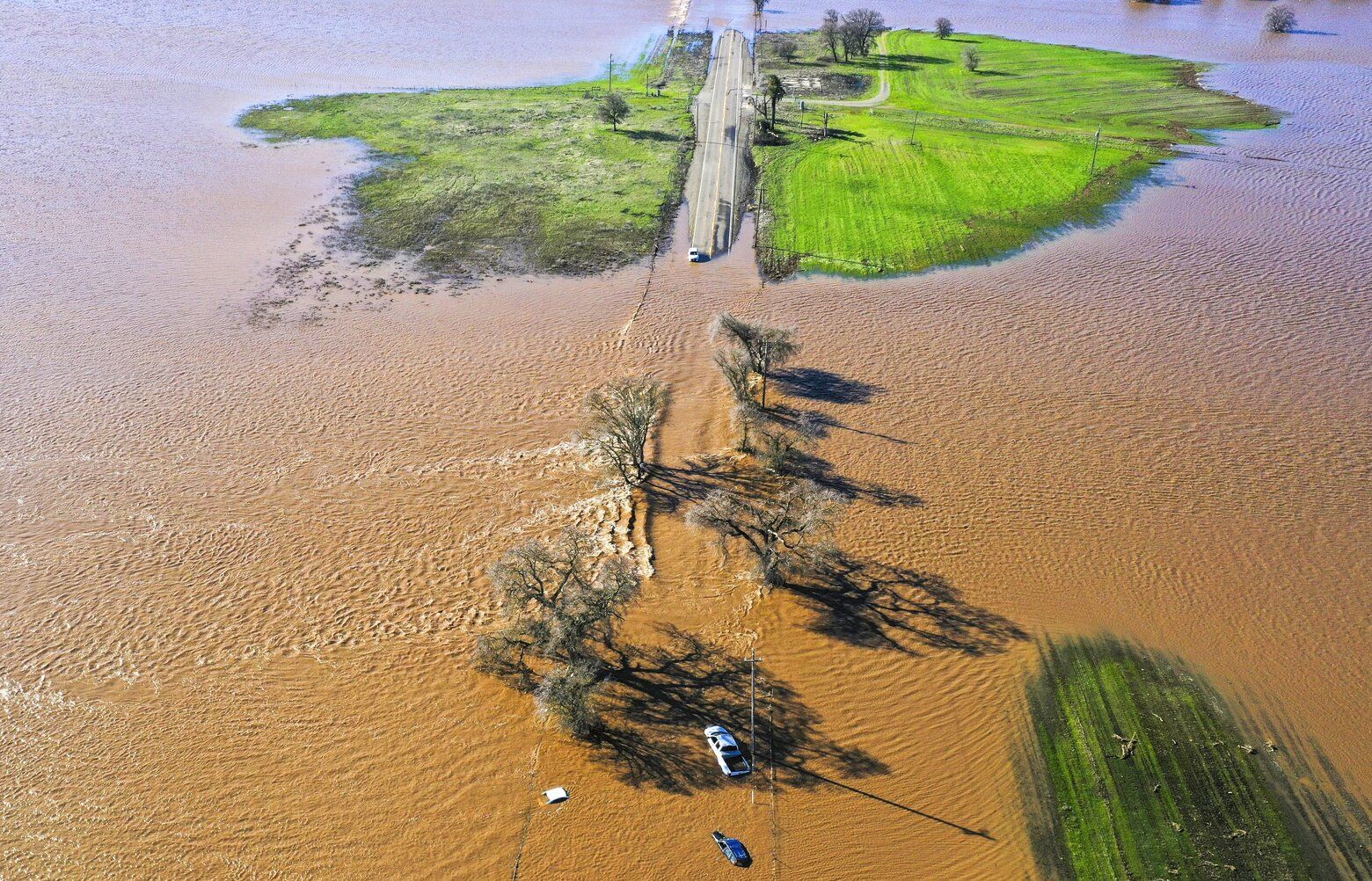 Three vehicles are submerged on Dillard Road west of Highway 99 in south Sacramento County in Wilton, Calif., Sunday, Jan. 1, 2023, after heavy rains on New Year’s Eve produced levee breaks. Saturday’s system was warmer and wetter, while storms this week will be colder, said Hannah Chandler-Cooley, a meteorologist at the National Weather Service in Sacramento. The Sacramento region could receive a total of 4 to 5 inches (10 to 13 centimeters) of rain over the week, Chandler-Cooley said. (Hector Amezcua/The Sacramento Bee via AP) CASAB701