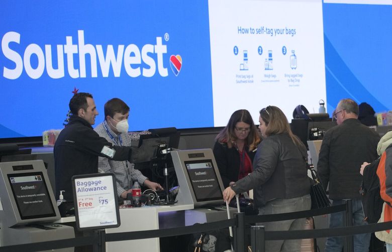 FILE – Travelers queue up at the check-in counters for Southwest Airlines in Denver International Airport, Friday, Dec. 30, 2022, in Denver. Southwest Airlines is trying to fix its relationship with travelers who got stuck by canceled flights over the holidays. (AP Photo/David Zalubowski, File) 