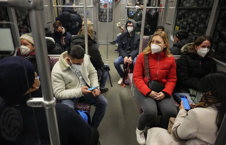 FILE – People wearing face masks to protect against coronavirus, travel on a metro in Berlin, Germany, March 31, 2022. A German doctor has been sentenced to two years and nine months in prison for illegally issuing more than 4,000 people with exemptions from wearing masks during the coronavirus pandemic. (AP Photo/Pavel Golovkin, File) DMSC102 DMSC102