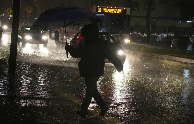A pedestrian crosses a partly flooded street in Berkeley, Calif. on Wednesday, Jan. 4, 2023. Gov. Gavin Newsom declared a state of emergency throughout California as an epic storm, the latest in a series of atmospheric rivers, slammed the state’s coast, claiming at least two lives. (Jim Wilson/The New York Times) XNYT62 XNYT62