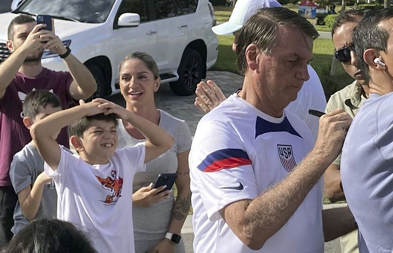 Former Brazil President Jair Bolsonaro, center, meets with supporters outside a vacation home where he is staying near Orlando, Fla., on Wednesday, Jan. 4, 2023. (Skyler Swisher/Orlando Sentinel via AP) FLORL201 FLORL201