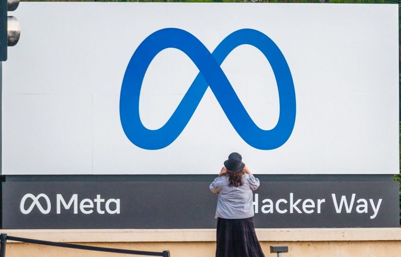 A visitor takes photographs of Meta Platforms signage outside the company’s headquarters in Menlo Park, California, U.S., on Friday, Oct. 29, 2021. (Nick Otto/Bloomberg)