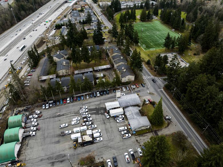 Seen from the air, the Federal Way operations and maintenance facility is a jumble of old buildings and crowded parking areas next to apartments and Interstate 5. A corner of Steel Lake Park Annex is at upper right. (Daniel Kim / The Seattle Times)