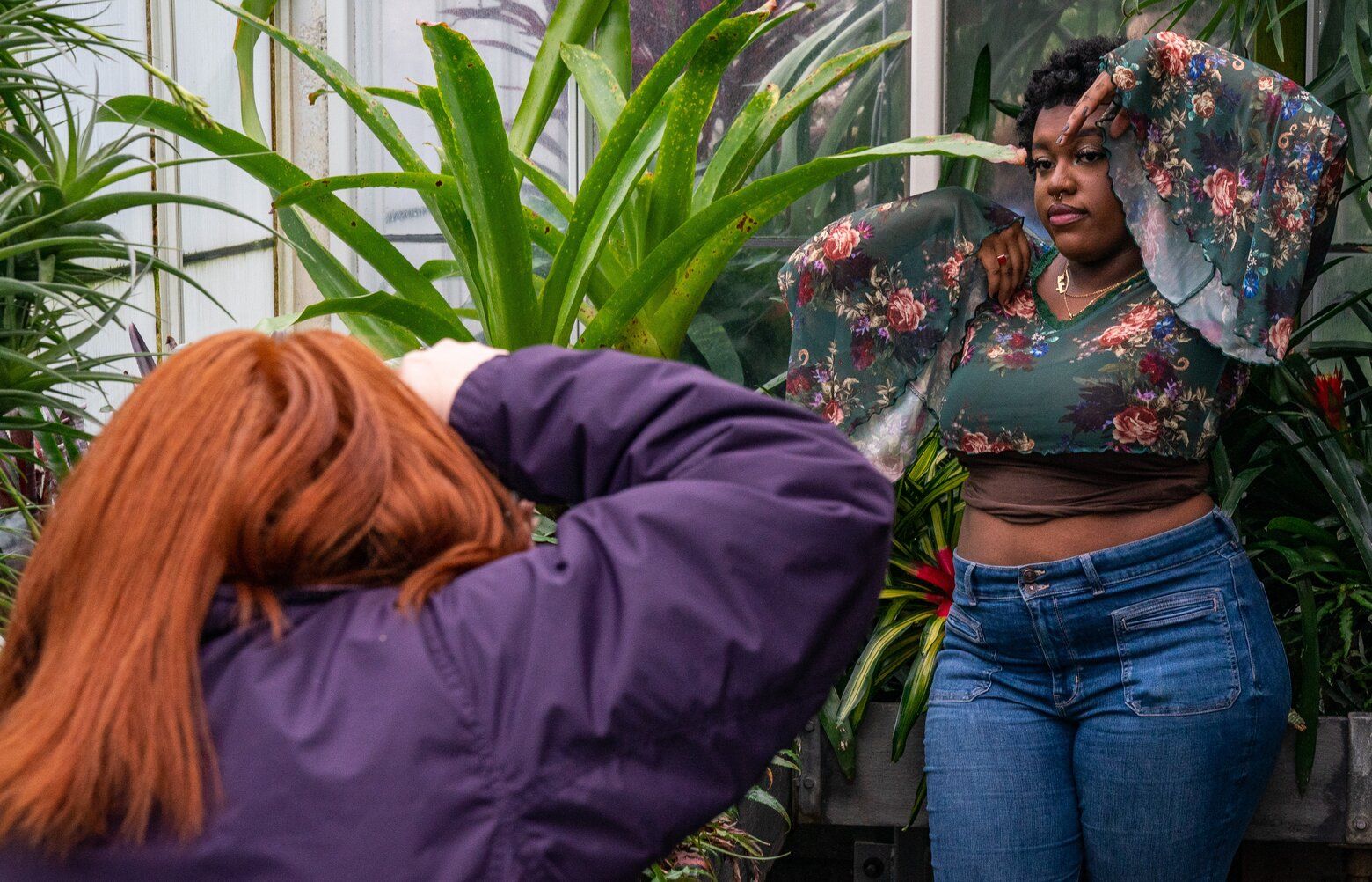 Jacquelyn Jimenez Romero, a student at the University of Washington, takes photos of her friend, Maia Roundtree, at Volunteer Park Conservatory on Sunday, Jan. 8, 2023. Roundtree wanted to take her high school senior year photos at the Conservatory because of “the vibes and the plants,” and Jimenez Romero said it’s one of the only scenic places in the city to take photos inside when it’s raining.