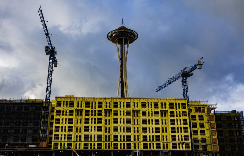 New apartments under construction are touted to open in the summer of 2023, near the Space Needle, Sunday, Dec. 18, 2022 in Seattle.