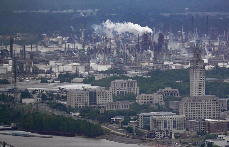 The Exxon Mobil Baton Rouge Refinery complex is visible with the Louisiana State Capitol, bottom right, in Baton Rouge, La., Monday, April 11, 2022. Exxon Mobil’s scientists were remarkably accurate in their predictions about global warming, even as the company made public statements that contradicted its own scientists’ conclusions, a new study says. (AP Photo/Gerald Herbert) LAGH304 LAGH304