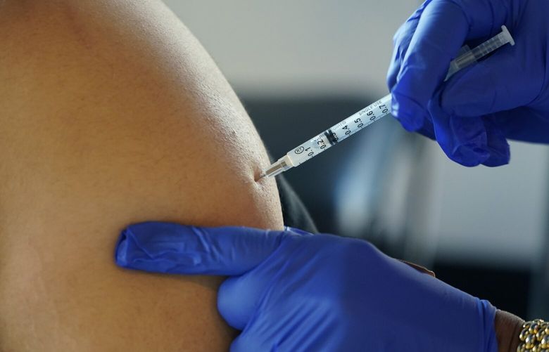 FILE – A Jackson, Miss., resident receives a Pfizer booster shot from a nurse at a vaccination site Feb. 8, 2022. On Friday, Jan. 6, 2023, The Associated Press reported on stories circulating online incorrectly claiming two researchers found that more than 1,500 athletes have suffered cardiac arrest since COVID-19 vaccinations began.  (AP Photo/Rogelio V. Solis, File) NYNR101 NYNR101
