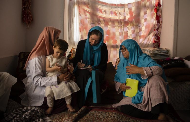 UNICEF staff members interview a woman about her health and her child’s health at a mobile clinic in the village of Alisha, in Wardak Province, Afghanistan, on June 11, 2022. Since the Taliban administration banned women from aid work, many groups have suspended their operations in the country and warned of permanently shutting down if the ban remains. (Kiana Hayeri/The New York Times) XNYT108 XNYT108