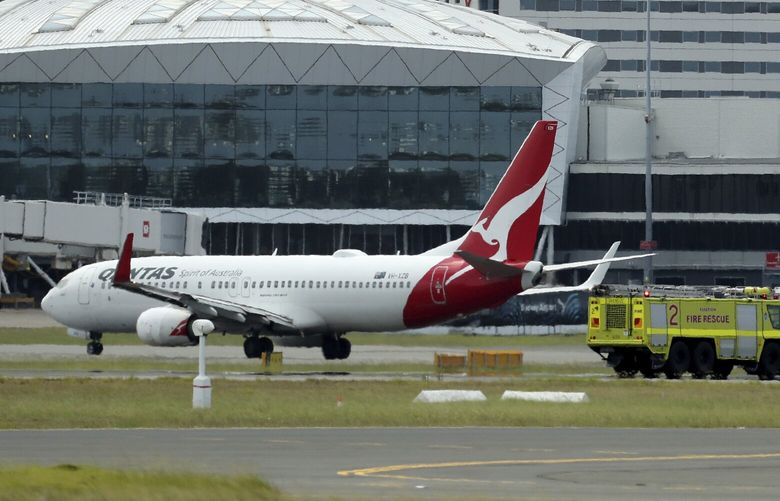 A Qantas jet is parked on the tarmac next to firetrucks at Sydney International Airport after making an emergency landing in Sydney, Wednesday, Jan. 18, 2023. The Qantas flight traveling from New Zealand to Sydney landed safely after it issued a mayday call over the Pacific Ocean. (Jeremy Ng/AAP Image via AP) SYD801 SYD801