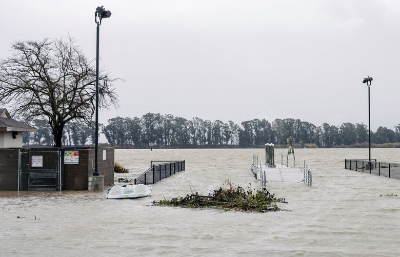 Flooding from the Sacramento River at a public boat launch in Rio Vista, Calif., on Saturday, Jan. 14, 2023. The state will soon get a chance to dry out and begin recovering from a relentless stretch of storms. (Ian Bates/The New York Times) XNYT18 XNYT18