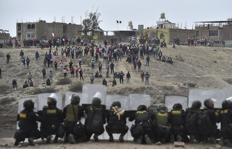 Anti-government protesters face off with security outside Alfredo Rodriguez Ballon airport in Arequipa, Peru, Thursday, Jan. 19, 2023. Protesters are seeking immediate elections, President Dina Boluarte’s resignation, the release of ousted President Pedro Castillo and justice for up to 48 protesters killed in clashes with police. (AP Photo/Jose Sotomayor) PER101 PER101