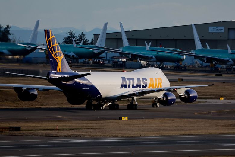 The very last new Boeing 747 taxis past a row of unfinished 777X aircraft Jan. 10 at Everett&#8217;s Paine Field as it gets ready for a test flight. Boeing will celebrate its final 747 handoff this week. This final jumbo jet has a split livery, with one side painted in the colors of the aircraft’s owner, Atlas Air, while the other side features the company that Atlas will operate the jet for, Apex Logistics. (Jennifer Buchanan / The Seattle Times)