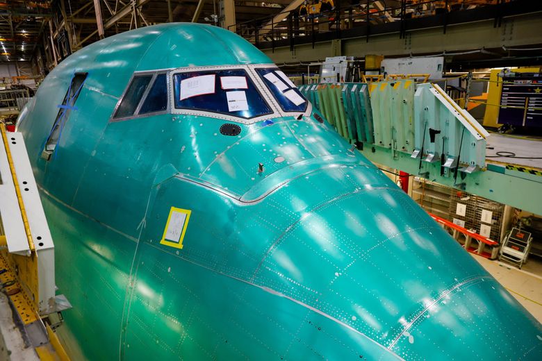 The giant nose section of the final 747 sticks up from beneath a deck before it is craned into position in front of the center fuselage during the final body join in September. (Jennifer Buchanan / The Seattle Times)