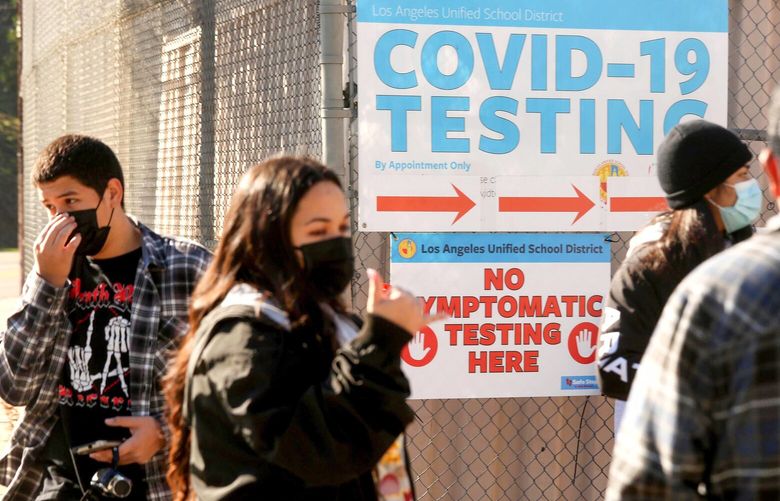 A support worker, second from left, directs Los Angeles Unified School District students and staff who wait in line for a COVID-19 test at a walk-up site at the El Sereno Middle School in the El Sereno neighborhood of Los Angeles on Jan. 4, 2022. (Genaro Molina/Los Angeles Times/TNS) 37242389W