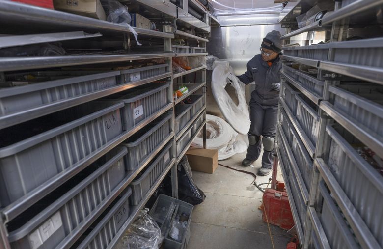 Tonya Miller, an apprentice plumber with Harts Services, picks out some PEX plastic tubing in the company’s work van parked in front of a Des Moines home. (Ellen M. Banner / The Seattle Times)