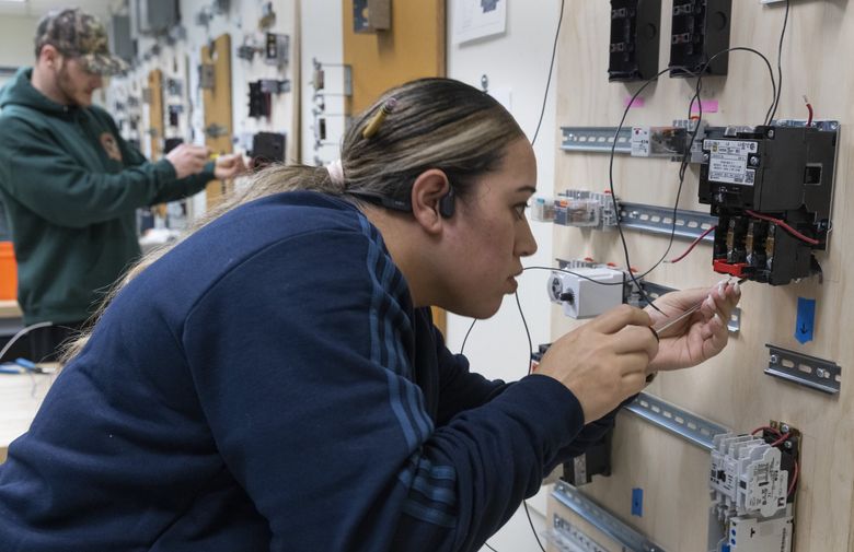 Penina Lelea of Renton, an electrician apprentice, works on components used in industrial motor control in her inside wire class in the Puget Sound Electrical Joint Apprenticeship and Training program in Renton. (Ellen M. Banner / The Seattle Times)