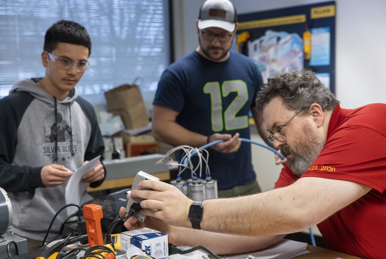 Instructor David Whitby, right, teaches AC Theory III to students Tyler Magat of Renton, left, and Josh Parkes of Puyallup at the Puget Sound Electrical Joint Apprenticeship and Training program in Renton. (Ellen M. Banner / The Seattle Times)