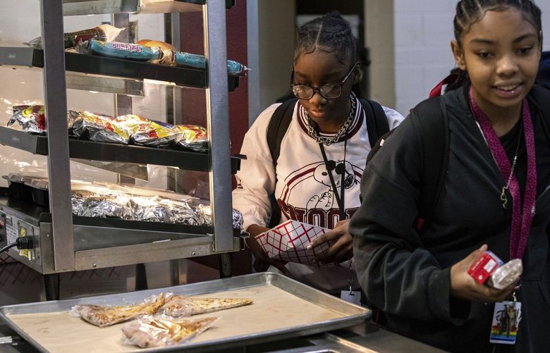 Students select food items at a self-service counter during lunch break at Tonalea K-8 school in Scottsdale, Ariz., Dec. 12, 2022. (AP Photo/Alberto Mariani) AZAM106 AZAM106