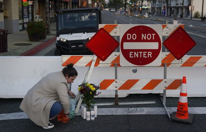 Stephanie Kozofsky, 31, leaves flowers and candles to honor the victims killed in Saturday’s ballroom dance studio shooting in Monterey Park, Calif., Sunday, Jan. 22, 2023. A gunman killed multiple people at the Star Ballroom Dance Studio late Saturday amid Lunar New Years celebrations in the predominantly Asian American community. (AP Photo/Jae C. Hong) CAJH144 CAJH144