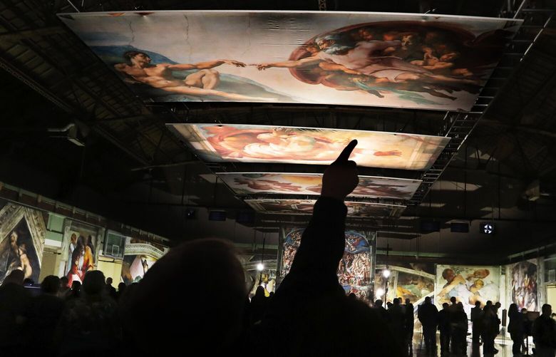 “The Creation of Adam,” one of 34 reproductions on display in “Michelangelo’s Sistine Chapel: The Exhibition” at the Tacoma Armory in 2018. (Alan Berner/The Seattle Times)

