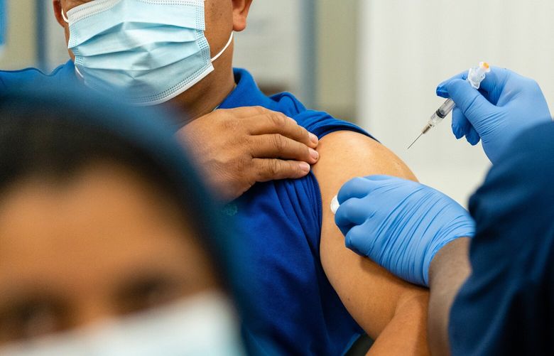 A health-care employee prepares to inject a patient with a dose of the Moderna coronavirus vaccine in November. MUST CREDIT: Photo for The Washington Post by Eric Lee