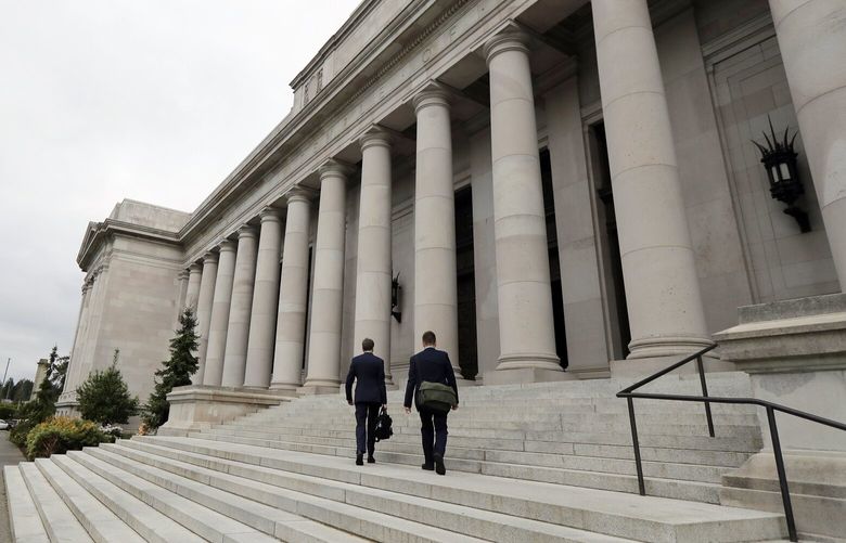 FILE – In this May 17, 2018, file photo attorneys walk up the steps of the Washington Supreme Court building, the Temple of Justice, in Olympia, Wash. The court on Thursday, Sept. 30, 2021, unanimously upheld the Washington’s tax on big banks aimed at providing essential services and improving the state’s regressive tax system. The 1.2% business and occupation surtax, a tax added on top of other taxes â€” was passed by the Legislature in 2019. (AP Photo/Ted S. Warren, File)