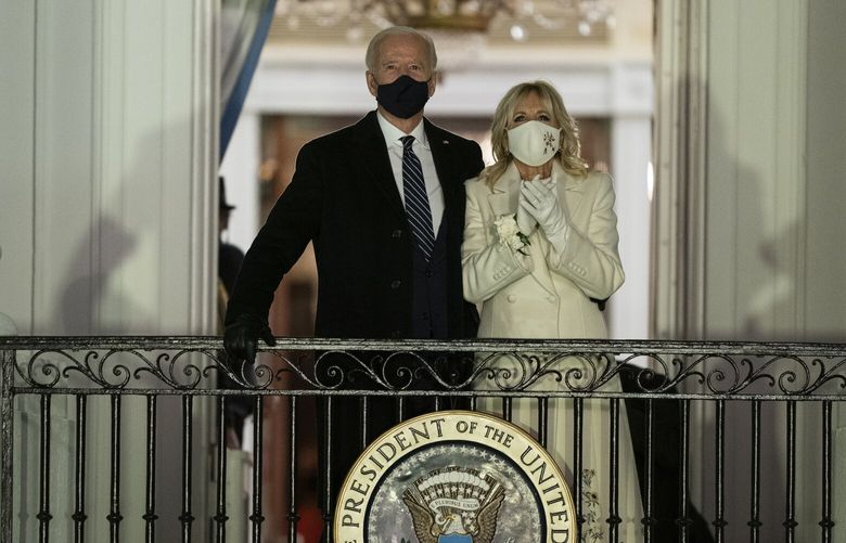 FILE – President Joe Biden and first lady Jill Biden watch fireworks from the White House, Jan. 20, 2021, in Washington. The ocean blue tweed dress and matching coat that Jill Biden wore for Joe Biden’s presidential inauguration is about to go on display at the Smithsonian’s National Museum of American History. In a rare move, the museum will also display the ensemble she wore for evening inaugural events, an ivory silk wool dress and matching cashmere coat. (AP Photo/Evan Vucci, File) WX202 WX202