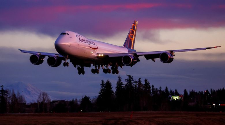 The sun sets on an era of aviation manufacturing as the very last Boeing 747 lands at Paine Field after a Jan. 10 test flight. The jet will be delivered on Tuesday to Atlas Air, which will operate the plane for freight forwarder Apex Logistics. One side of the aircraft is painted in the colors of Atlas, the other side in the livery of Apex. (Jennifer Buchanan / The Seattle Times)